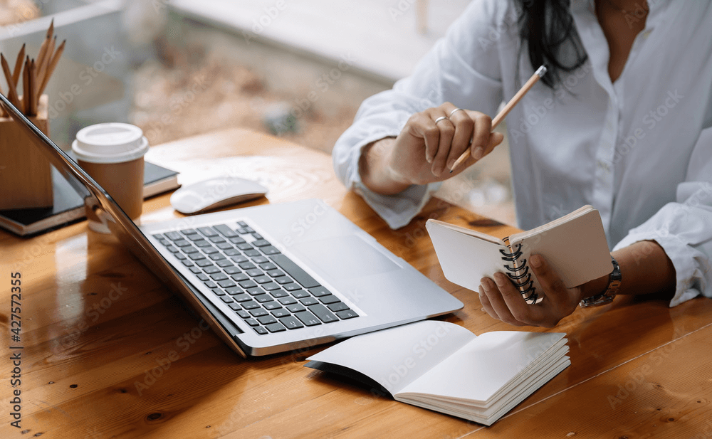 Person studying with notebook and laptop